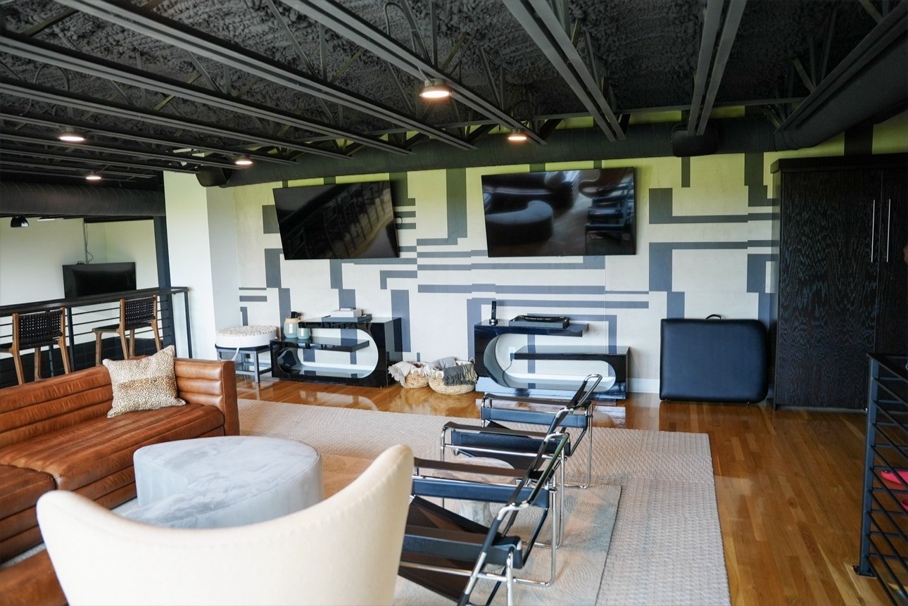 Loft viewing lounge with dual media walls above the court